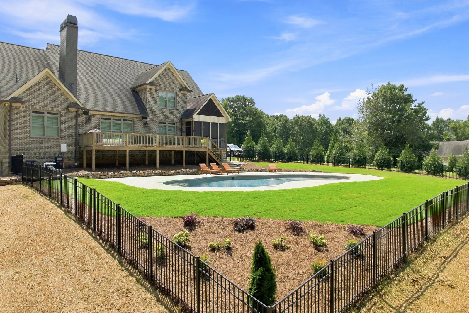 Barker Road in Rome, GA, after BDS Landscape Co. finished: sod laid to the pool deck, a planted bed and an ornamental aluminum fence